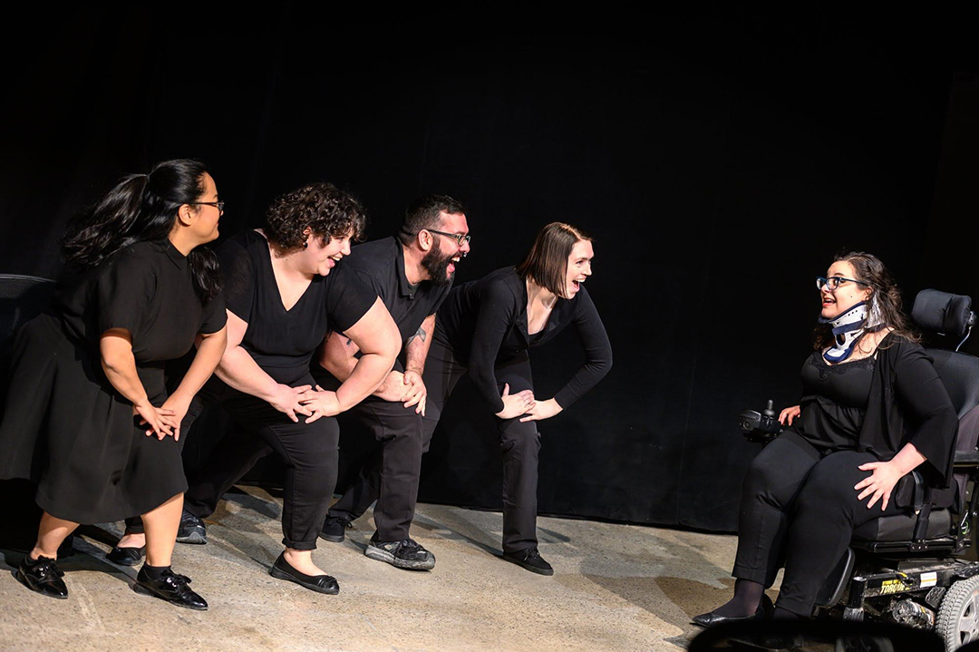 Four people facing Ophira with their hands on their knees.