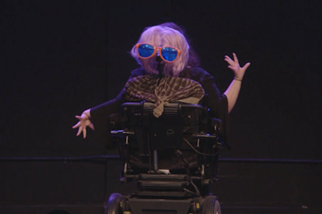 Ophira facing away with a wig and glasses on their head rest.